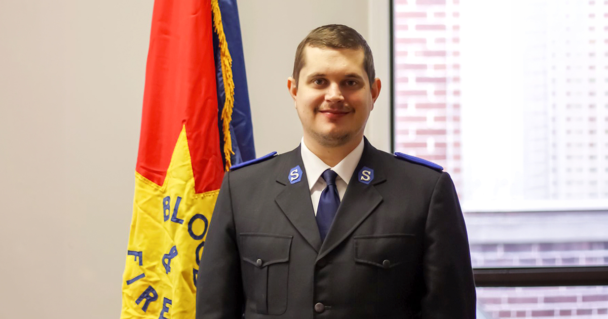 A man standing beside a Salvation Army flag
