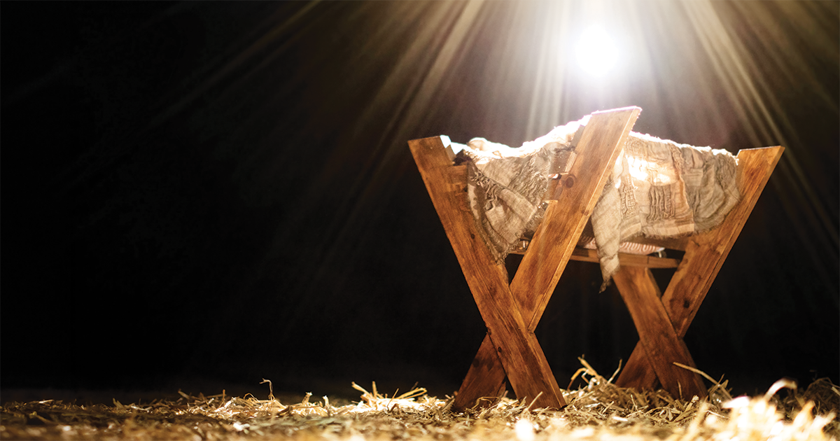 A brightly lit manger on a dark background